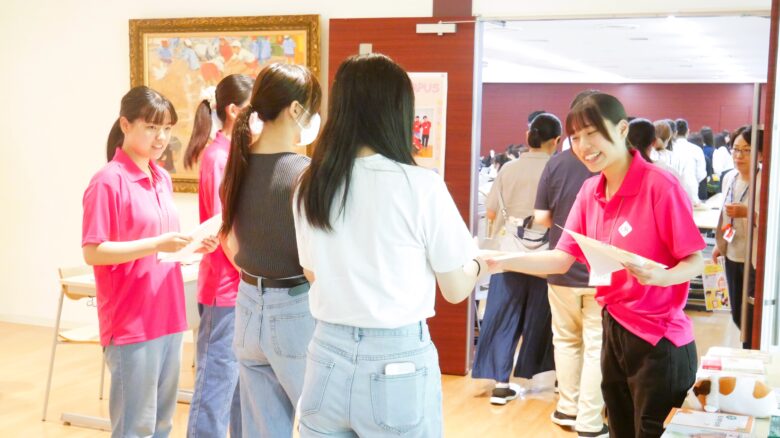 会場入り口で、学生が資料を笑顔で手渡ししました(^^♪